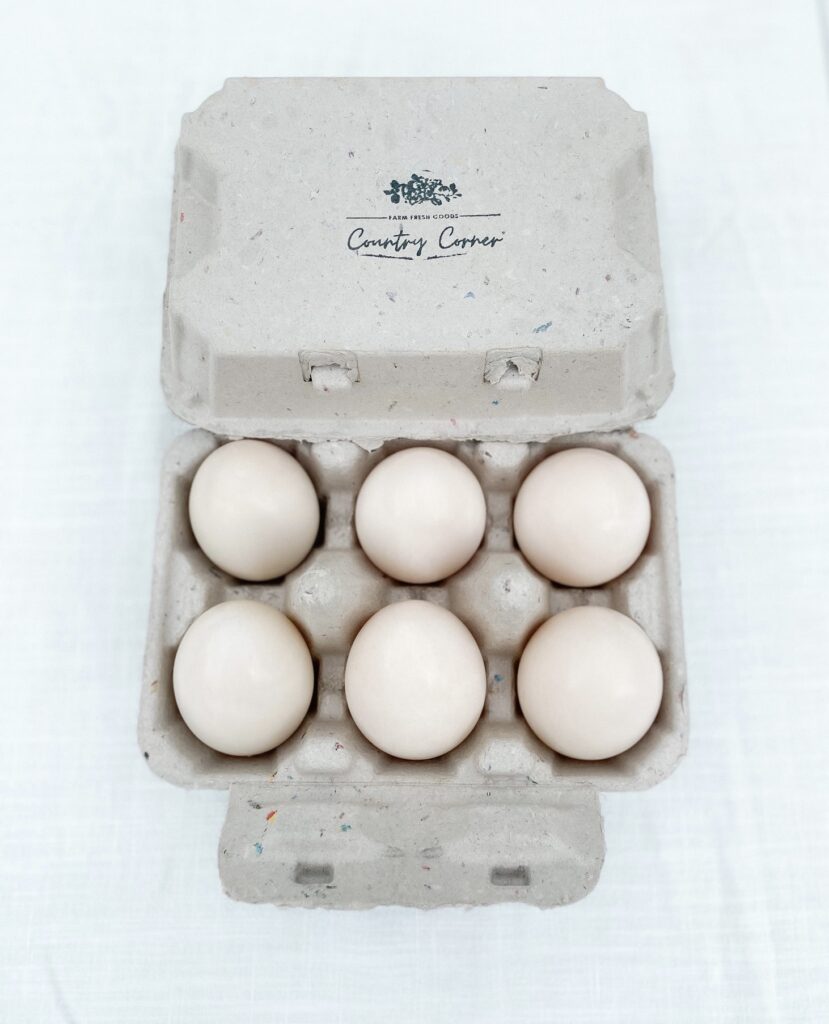 Gray egg carton with country corner logo stamp on lid holding 6 large white duck eggs.
