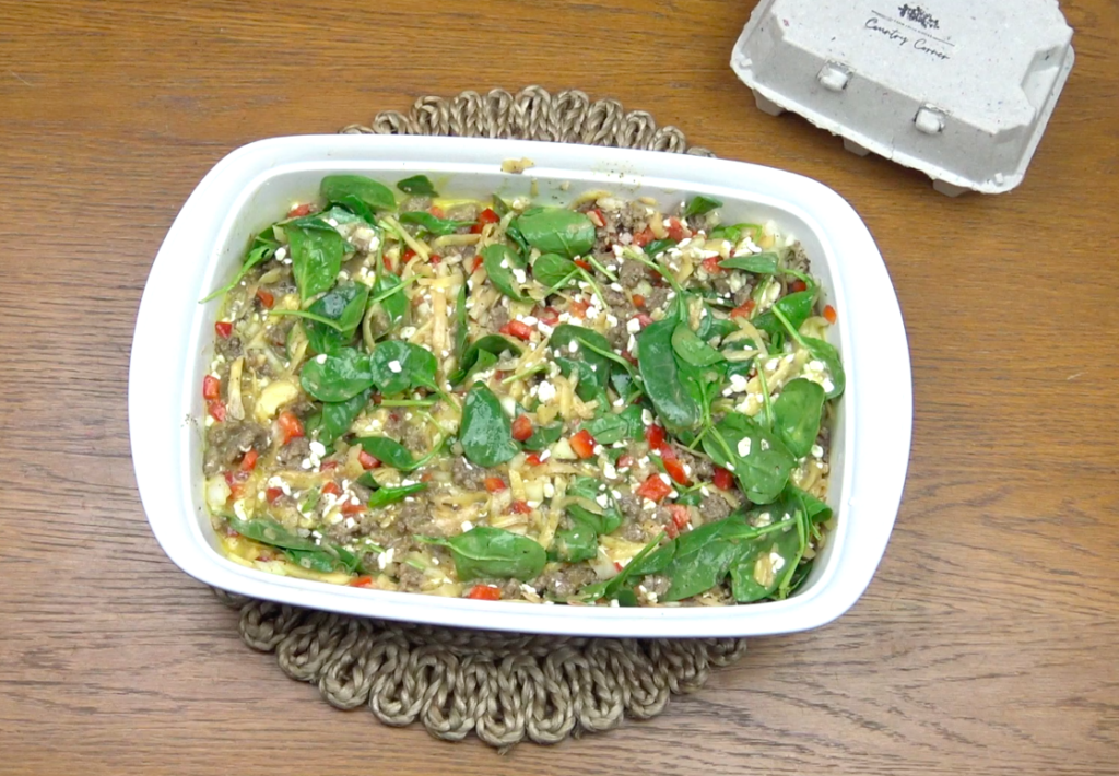 Egg casserole ingredients mixed together in dish on table and saucer.